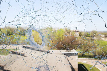 Broken glass on the background of blue sky and buildings