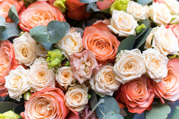 Wedding bouquet of orange and white roses, lisianthus and eucalyptus