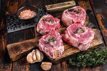 Raw mutton lamb neck meat on a butcher board with cleaver. Dark wooden background. Top view