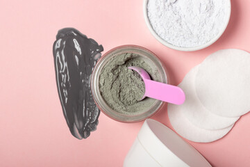 An open cosmetic jar, against the background of a smeared cream or cosmetic face mask. Purifying and moisturizing clay mask. Top view, flat lay
