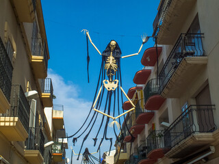 Una imagen de un esqueleto cuelga entre las fachadas de dos edificios para celebrar Halloween