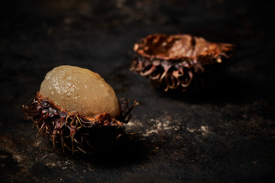 Macro view of rambutan on dark rustic wooden background