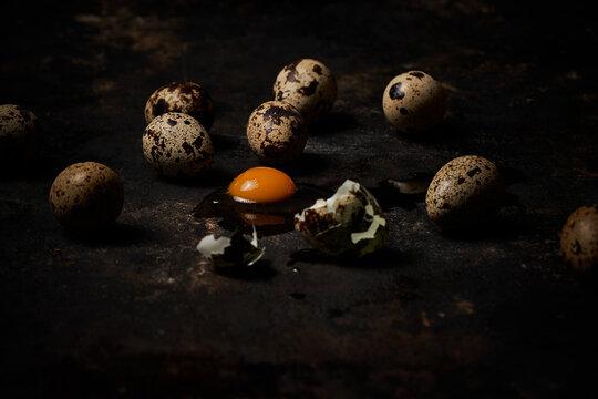 Side view of a group of quail eggs on dark rustic wooden background
