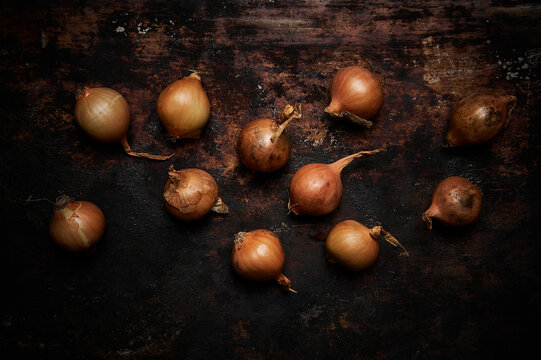Top view of group of onions on dark rustic wooden background