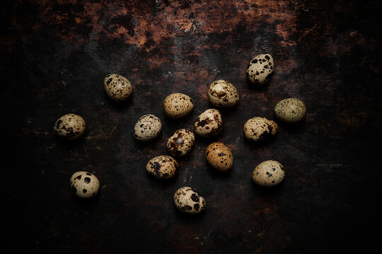 Top view of a group of quail eggs on dark rustic wooden background
