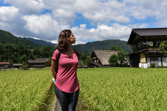 Young caucasian woman in an open field in historical Japanese village and UNESCO World Heritage Site Shirakawa-Go, Japan