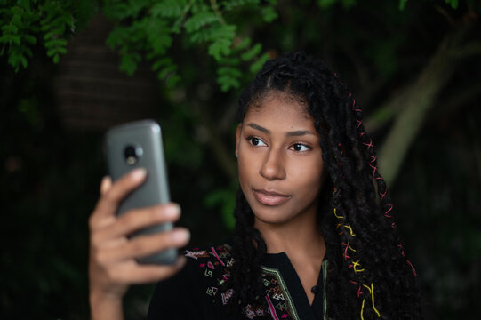Young attractive afro latina woman taking a selfie with smartphone