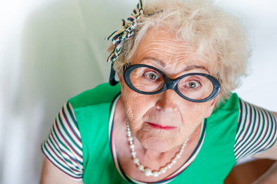 Elderly stylish woman with a angry surprised expression on her face top view. Old woman with an indignant face. Angry fashionable grandmother. Discontent, surprise and shock granny