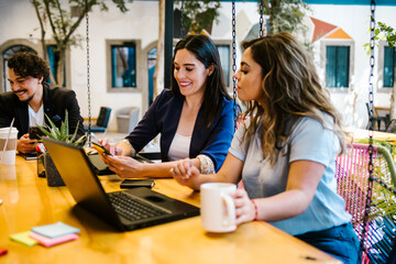 latin women working with laptop and phone in a creative office in Mexico city