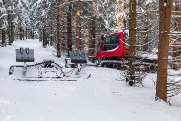 Naklejka premium red snowmobile in the winter snowy forest
