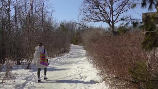 The girl carefully walks along the icy path in the park