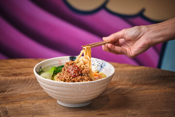 Stock photo of unrecognized person enjoying noodles soup in japanese restaurant.