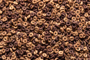 Chocolate cereals background. Breakfast cereal rings, full-frame, top view.