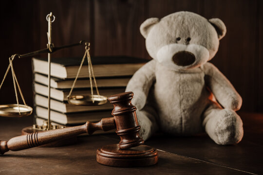 Divorce at family and alimony concept. Wooden gavel and teddy bear as symbol of child on a desk.