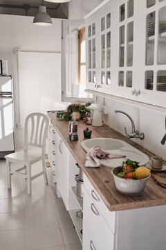Interior of stylish kitchen with white furniture and various appliances in contemporary apartment