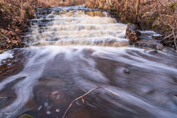 waterfall in several stages and fallen leaves