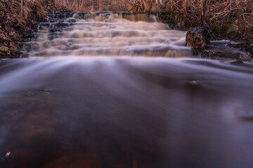 waterfall in several stages and fallen leaves