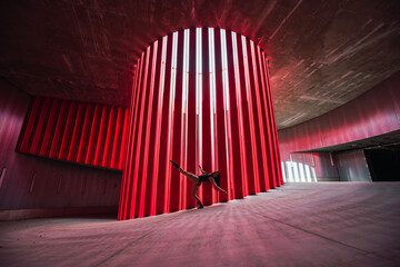 Side view of anonymous female theater artist stretching leg while preparing for performance on stage in daytime