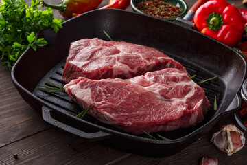 Raw Fresh Meat Steak with Ingredients and Fried Grill Frying Pan.sliced raw pork meat with rosemary.