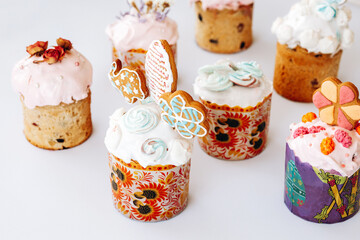 Set of Easter cakes decorated with cookies, bize and flowers. Homemade Easter baking in forms with ornaments on a white background