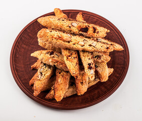 Biscotti on a brown plate on white background with clipping path