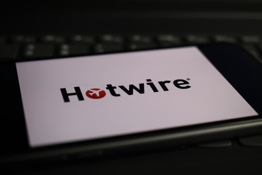 Viersen, Germany - March 1. 2021: Closeup of mobile phone screen with logo lettering of hotwire online travel agency on computer keyboard