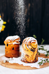 Homemade Easter cake with raisins and poppy seeds and powdered sugar on a wooden plate