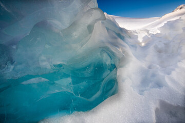 Türkisblaue Eisgebilde auf zugefrorenem Bergsee