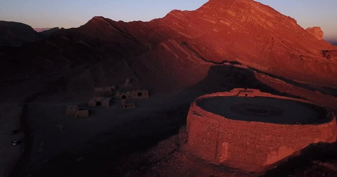 Travel to Iran to Visit Ruins of Ritual Buildings Next to Zoroastrians Cemetery Dakhmeh Towers of Silence Old City Around Yazd in Orange Color Sunset Close to Horizon Shadow and Mountains Landscape