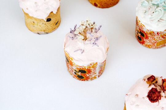 Set of Easter cakes decorated with cookies, bize and flowers. Homemade Easter baking in forms with ornaments on a white background