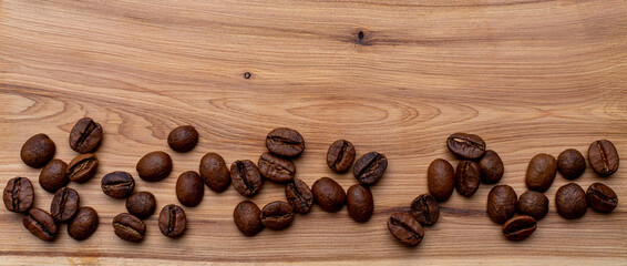 Coffee beans on a wooden background banner, place for the inscription.