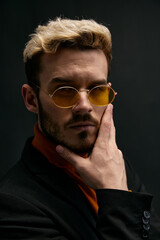 Obraz premium portrait of an attractive blond man gesturing with his hands on a dark background 