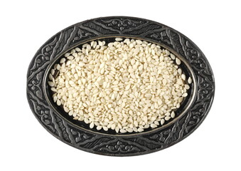 Sesame seeds in embroidered, embossed silverware pot, bowl isolated on white background, top view