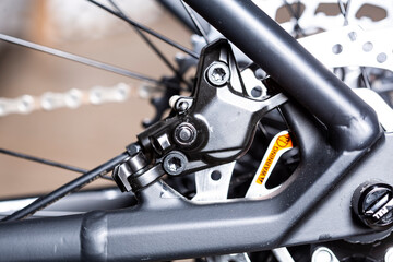 Obraz premium Modern Rear disk brake on a mountain bike with black frame close up detail