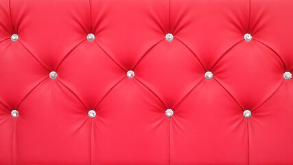 Stylish red soft leather upholstery of sofa. The material is decorated with buttons in the form of crystals. Upholstery leather pattern background.