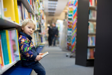 Adorable little boy, sitting in a book store
