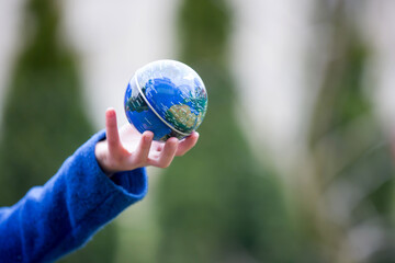 School child, holding small globe, looking sad at the world during Covid 19 pandemic