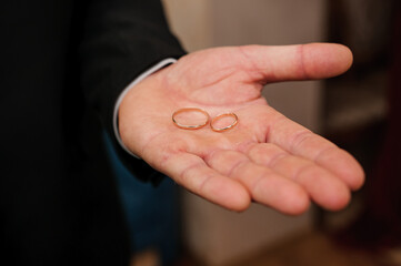 Wedding gold rings in the hands of the groom