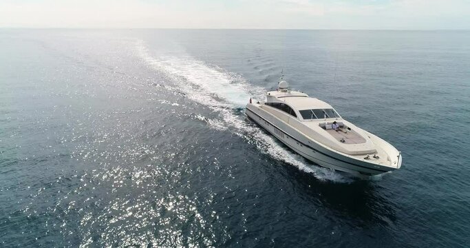 Aerial view with a red camera in 4K of a Luxury Yacht sailing in the Mediterranean Sea in France, with the sunlight in the background 