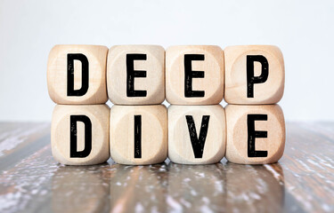 Modern business buzzword - deep dive. Top view on wooden table with blocks.