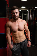 Fototapeta na wymiar Strong man with muscular body type posing in modern sports hall.