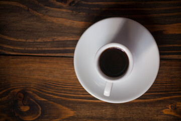 A cup of aromatic black coffee. Morning espresso or Americano coffee for breakfast in a beautiful cup. Wooden background. 