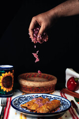 chef serving onion over the cochinita pibil tacos