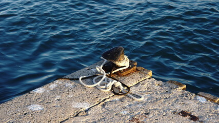 Bollard roped around with a boat mooring