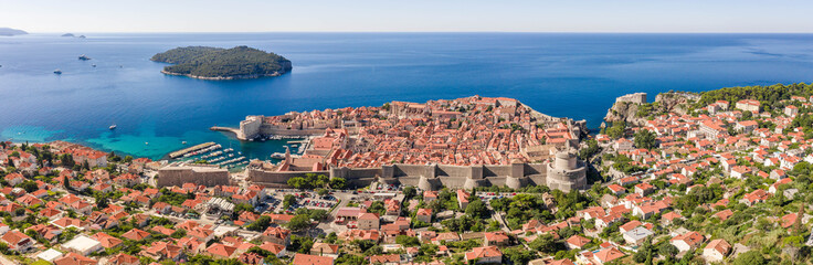 Aerial panorama drone shot of Dubrovnik old town by Adriatic sea with view of Lokrum Island in Croatia summer morning