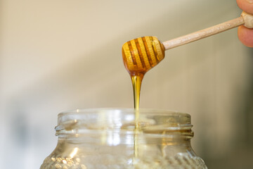 Raw tasty Honey on a wooden dipper closed up,Breakfast healthy ingredients