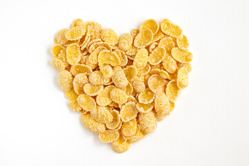Heart made of corn flakes isolated on white background.
