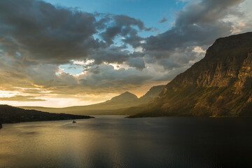 Fototapeta na wymiar dramatic golden summer sunrise in St Mary's lake in Glacier national park in Montana.