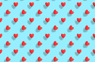 Pattern of red hearts with shadows on the blue background