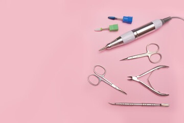 Nail tool. Professional steel manicure and pedicure tools. Manicure scissors, tongs, cutter, clipper and nozzles for polishing nails on a pink background